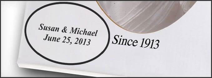 Close-up of a printed card displaying the text "Susan & Michael June 25, 2013" inside an oval and "Since 1913" beside it.